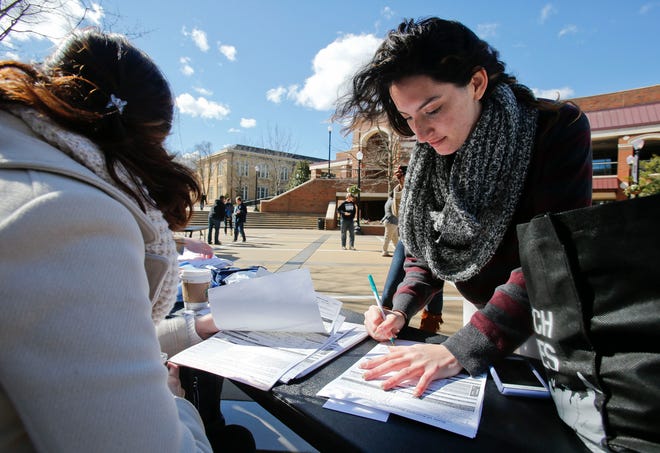Members of the student chapter of the Southern Poverty Law Center at the University of Alabama hold a "Get Out The Vote" rally outside the Ferguson Center Monday, February 8 2016. Margaret Sasser, left, helps Samantha Rubinchik register. Staff Photo/Gary Cosby Jr.