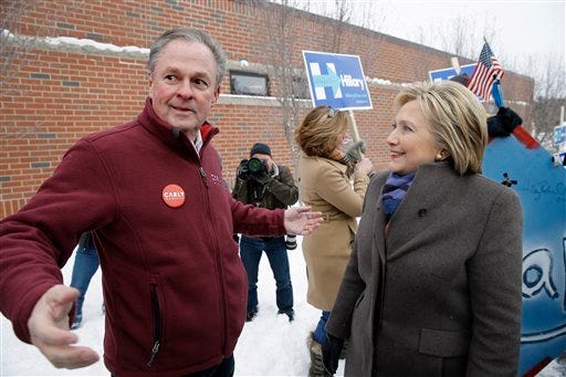 Democratic presidential candidate Hillary Clinton speaks with Frank Fiorina, husband of Republican presidential candidate Carly Fiorina, as they campaign outside a polling place during the first-in-the-nation presidential primary, Tuesday, Feb. 9, 2016, in Derry, N.H.