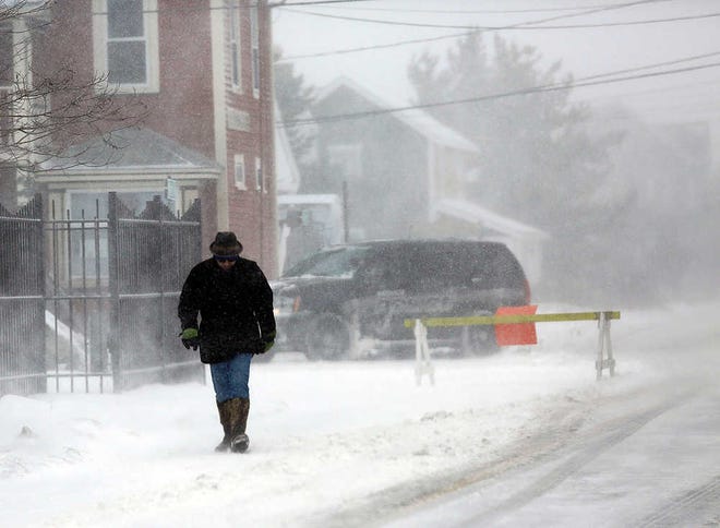 A man makes his way along Central Ave in Humarock, Scituate, Mass., Monday, Feb. 8, 2016. (Greg Derr/The Quincy Patriot Ledger via AP)