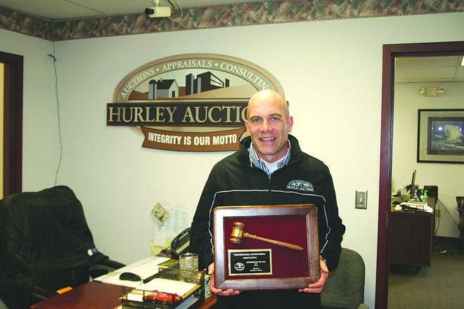 Matthew Hurley has a plaque and six small trophies for winning awards at a state convention. He was named Auctioneer of the Year in Pennsylvania.