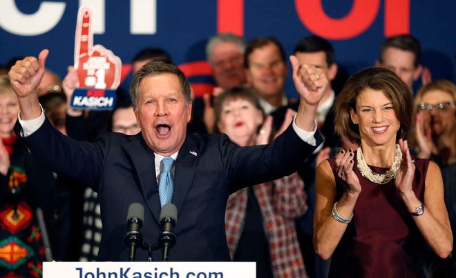 With his wife Karen at his side Republican presidential candidate Ohio Gov. John Kasich cheers with supporters Tuesday, Feb. 9, 2016, in Concord, N.H., at his primary night rally.