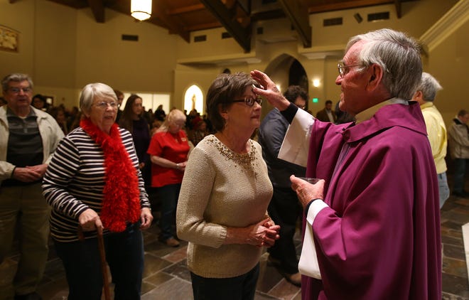 The Rev. Jerry Deasy places ashes on a parishioner's forehead reminding her to turn away from sin during an Ash Wednesday Mass at Holy Spirit Catholic Church in Tuscaloosa on Wednesday.