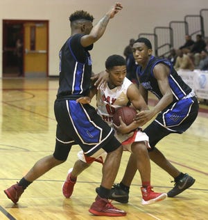 Bay’s Marcus Jones (0) is double teamed by Godby defenders Tre Clemons (left) and Jajuan Pinkard.