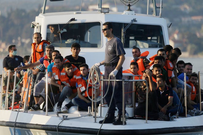 FILE - In this file photo taken on Wednesday, June 17, 2015, a Greek Coast Guard vessel arrives carrying migrants at the port of Mytilene, Greece, after a rescue operation on the northeast Greek island of Lesvos. NATO's European commander on Thursday, Feb. 11, 2016, ordered three warships to move immediately to the Aegean Sea to help end the deadly smuggling of migrants between Turkey and Greece. (AP Photo/Thanassis Stavrakis, File)