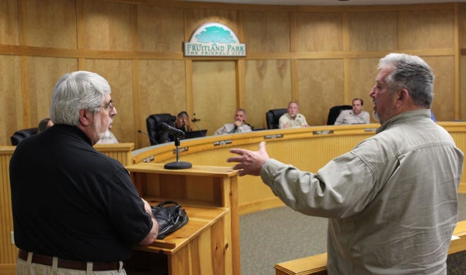 Leesburg architect James A. Senatore, left, and Fruitland Park Community Development Director Charlie Rector discuss contract terms with commissioners.