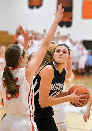 Jill Berg of Midwest Central turns to the basket as Brianna Grotts of Illini West defends during Thursday's regional 2A final.