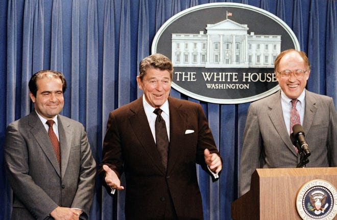 FILE - In this June 17, 1986 file photo, President Ronald Reagan speaks at a news briefing at the White House in Washington, where he announced the nomination of Antonin Scalia, left, to the Supreme Court as a result of Chief Justice Warren E. Burger's resignation. William Rehnquist is at right. On Saturday, Feb. 13, 2016, the U.S. Marshals Service confirmed that Justice Scalia has died at the age of 79. (AP Photo/Ron Edmonds)