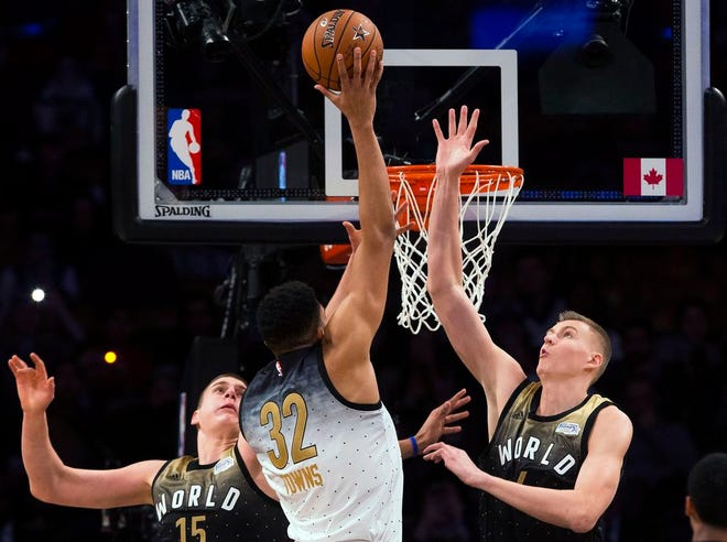 U.S. forward Karl-Anthony Towns (32) drives to the net past World's Nikola Jokic (15) and Kristaps Porzingis during the first half of the NBA Rising Stars Challenge in Toronto on Friday night.
