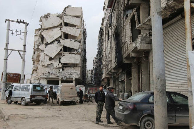 In this Thursday, Feb. 11, 2016 photo, a building is seen with heavy damage in Aleppo, Syria. The fighting around Syria's largest city of Aleppo has brought government forces closer to the Turkish border than at any point in recent years, routing rebels from key areas and creating a humanitarian disaster as tens of thousands of people flee. (Alexander Kots/Komsomolskaya Pravda via AP)