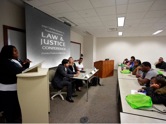 University of Florida law student Colette Harris, left to right, law student Kaizad Irani, Stephanie Marchman, Esq., and law student Natasha Williams, answer questions for local students, the Jesus People of Life Changing Church, at right, attending the Josiah T. Walls Bar Association, Inc.'s Fourth Annual Law & Justice Conference at the Levin College of Law at UF, Saturday, February 13, 2016 in Gainesville, Fla.