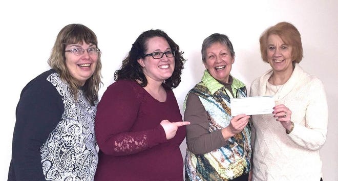 Sampson Committee Chair Grace Knapton, Director Becky Prine, and PYTCo. General Manager Peg Patterson accept a check for $3,562 from Terri Fingar of The Living Well, as their half of the proceeds from “A Charlie Brown Christmas.”