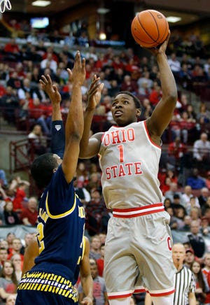 Ohio State's Jae'Sean Tate, right, goes up for a shot against Michigan's Muhammad-Ali Abdur-Rahkman during the second half of an NCAA college basketball game in Columbus, Ohio, Tuesday, Feb. 16, 2016. Ohio State won 76-66. (AP Photo/Paul Vernon)