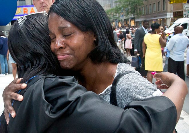 In this June 9, 2015 photo, Candie Hailey, right, cries as she hugs her younger sister, Chyna, following her college graduation ceremonies in New York. "I am proud of you," said Candie. "We been through a lot." Hailey dropped out of high school to help care for Chyna and another sister, and later earned an equivalency diploma and a college degree before Rikers Island prison made her a "solitary survivor." (AP Photo/Bebeto Matthews)