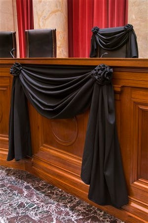 This photo provided by the Collection of the Supreme Court of the United States shows Supreme Court Associate Justice Antonin Scalia's bench chair and the bench in front of his seat draped in black on Tuesday, Feb. 16, 2016, at the court in Washington, following his death on Feb. 13.