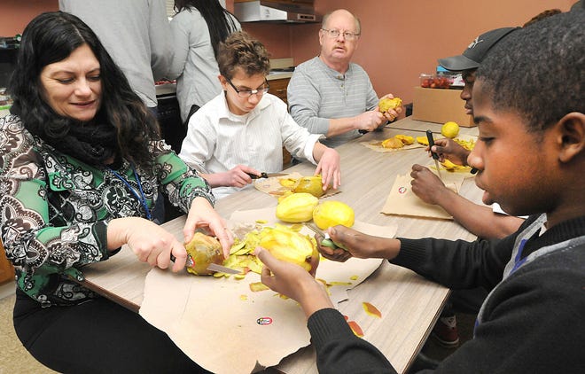 Michelle DiSipio (left), ATG Learning Academy teacher, student Colby Schnell, Jerry Krone, Bucks County Preserves, in Fountainville, and student Zane Bolden start the process of making jam by peeling mangoes that will go into the mango-strawberry jam.