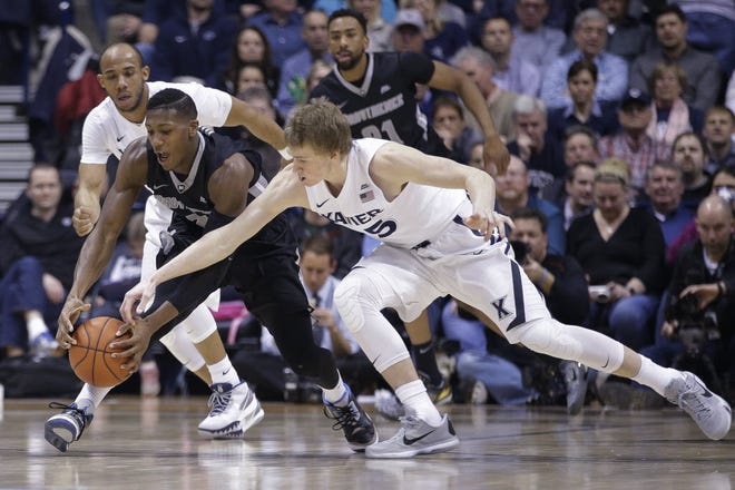Providence's Kris Dunn, center, and Xavier's J.P. Macura, right, scramble for the ball during the first half.