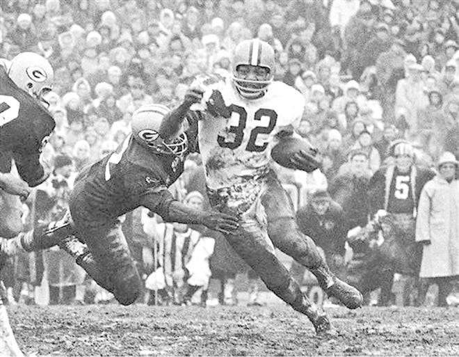 Jim Brown turns the corner for the Cleveland Browns as a Green Bay Packer defender swings with him during a Jan. 2, 1966, football game in Green Bay, Wisconsin. 

AP File Photo