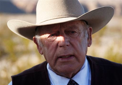 FILE - In a Wednesday, Jan. 27, 2016 file photo, rancher Cliven Bundy speaks to media while standing along the road near his ranch, in Bunkerville, Nev. A federal grand jury in Nevada indicted Cliven Bundy and four others Wednesday, Feb. 17, 2016, on 16 charges related to an armed standoff near his ranch in 2014 over unpaid grazing fees. Bundy is accused of leading "a massive armed assault" of 200 followers to stop federal law agents who were rounding up about 400 of Bundy's cattle on federal lands in April 2014, according to documents filed by U.S. attorneys Wednesday. (AP Photo/John Locher, File)