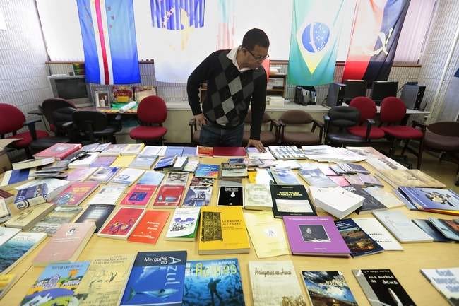 Dr. Carlos A. Almeida, Bristol Community College's director of LusoCentro, takes a look at some of the books donated to the school by the Regional Department for the Communities of the Azorean Government.