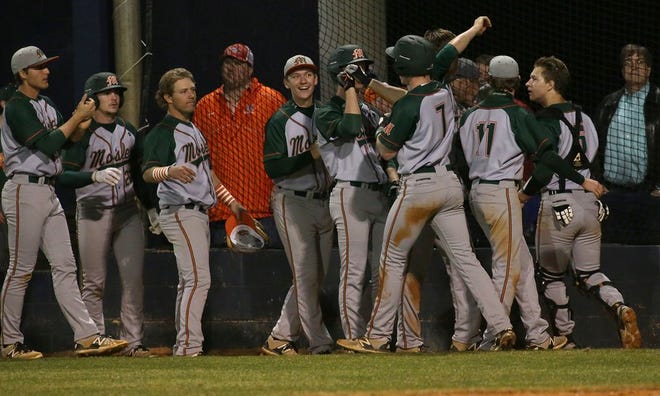 Mosley players celebrate after scoring a run during Friday night's win over Arnold.