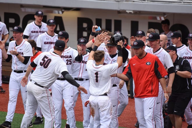 Georgia catcher/outfielder Skyler Weber (1) is greeted by his team after making it to home base during an NCAA baseball game between Georgia and Georgia Southern at Foley Field in Athens, Ga. on Sunday, Feb. 21, 2016. (UGA sports communications)