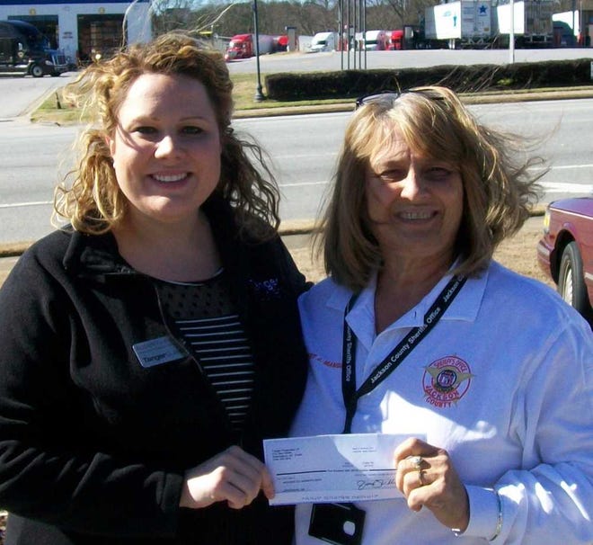 Elizabeth Evans, Tanger Outlets Assistant General Manager, presents donation to Jackson County Sheriff Janis Mangum.