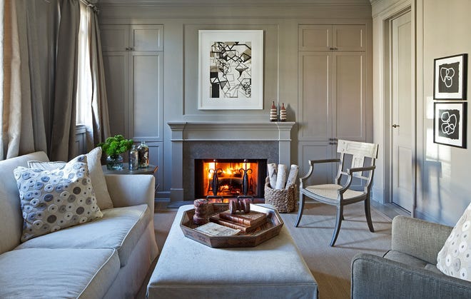 A fire crackles in a gray family room in a Washington townhouse designed by Mary Douglas Drysdale.