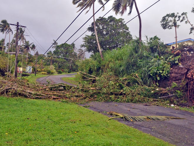 A tree lays across a road and power lines in Lami, Fiji, Sunday, Feb. 21, 2016, after cyclone Winston ripped through the country. Officials in Fiji are assessing damage in the wake of the ferocious cyclone that tore through the Pacific island chain.