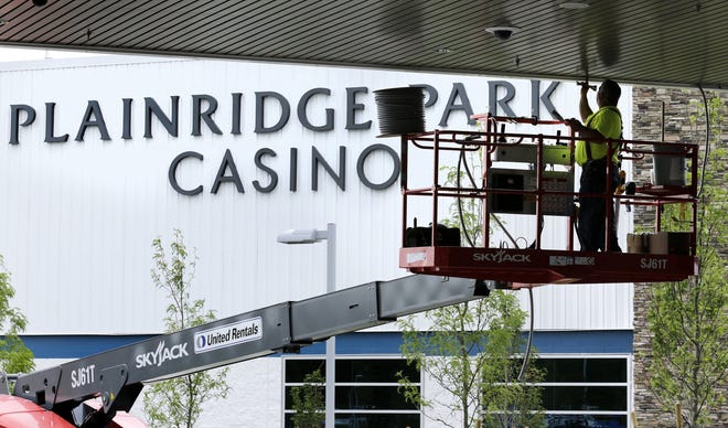 A worker caulks the roof of the entrance to the Plainridge Park Casino in Plainville, Mass., in 2015. Despite a better month in January, the state’s first casino has an uphill climb to meet initial opening-year revenue projections. AP Photo/Charles Krupa