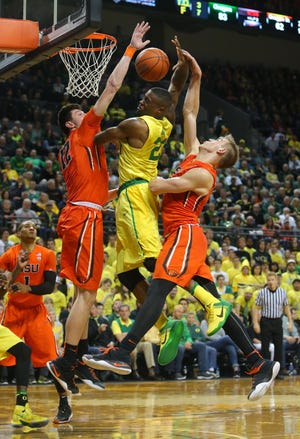 Elgin Cook is fouled at the hoop during Oregon's 91-81 victory over Oregon State in Eugene, Ore. Saturday, February 20, 2016. (Brian Davies/The Register-Guard)