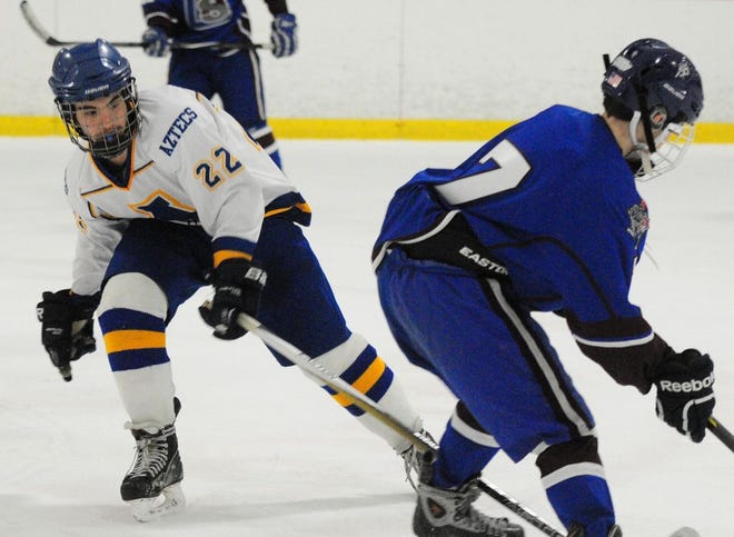 Assabet's Adam Melidio (left) tries to knock away the puck from Lunenberg's Jacob Mauro (right).