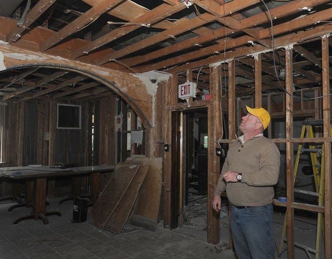 Junior Paquette, VP of the Academica Club, looks at the open beams in the roof where the materials were removed after the extensive water damage on Valentines day.