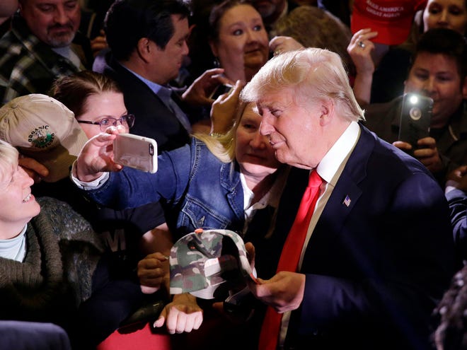 Republican presidential candidate Donald Trump takes pictures with supporters during a rally Tuesday, Feb. 23, 2016, in Reno, Nev.