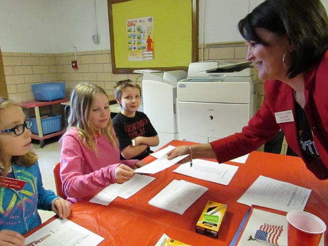 Logan County Clerk and Recorder Sally Turner, right, helps Washington-Monroe student election judges from right: Ethyn, Cydney and Hailie during Tuesday’s mock election at their school. Photo by Jean Ann Miller/The Courier