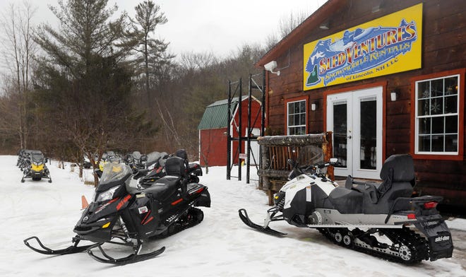 Rental snowmobiles sit idle Wednesday Feb. 24, 2016, in Lincoln, N.H. A warm winter has closed thousands of miles of snowmobile trails in northern New England and could jeopardize money that clubs hoped to get in future years. (AP Photo/Jim Cole)