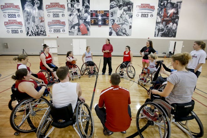 Elisha Williams,head coach for the University of Alabama's Adapted Athletics Women's Wheelchair Basketball team, standing in the center, gives direction to her team as the conclude practice. Staff Photo/Gary Cosby Jr.