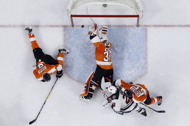 Flyers goalie Michal Neuvirth blocks a shot by Minnesota's Charlie Coyle past Radko Gudas (left) and Nick Schultz, of the Flyers, and Thomas Vanek, of the Wild, during the final seconds on Thursday, Feb. 25, 2016. The Flyers won 3-2.