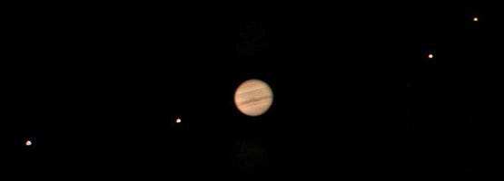 Jupiter, showing two of its moons on either side. This is a photograph that was taken by Jan Sandberg with a 10” telescope. Wikimedia Commons