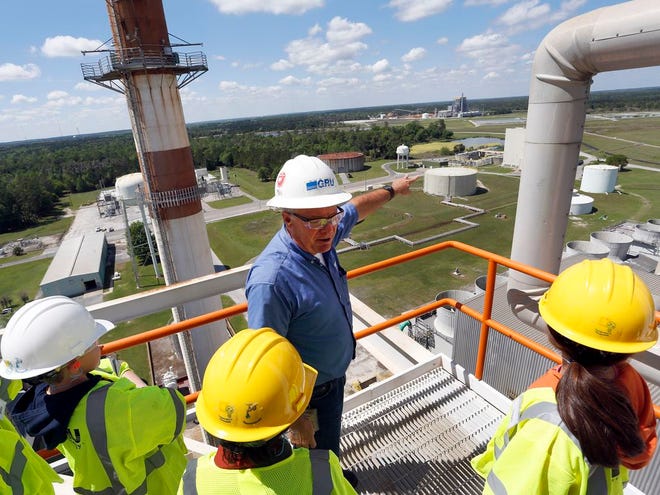 Joe Shaw, center, a utility project leader and former plant manager, leads middle school students attending the 2015 GRU Camp emPower on a tour of the Deerhaven Generating Station, the largest power plant in Gainesville. Guardian file photo