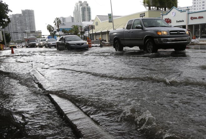 Vehicles negotiate flooded streets in Miami Beach.
