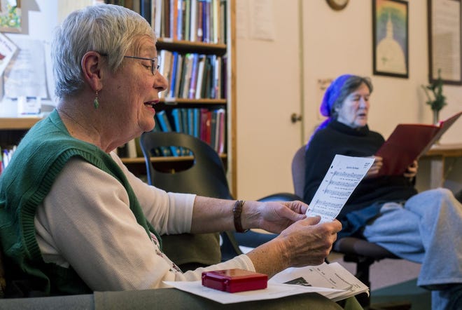Jean Drumm, left, and Sophia Compton rehearse “Keep Me in this Moment” on Feb. 10 at Oread Friends Meeting house in Lawrence. The women are members of the Sunflower Threshold Choir, the Lawrence branch of a network of choirs dedicated to singing for those at the threshold of life and death.