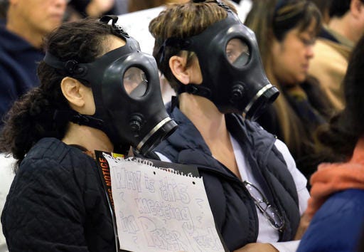 FILE - In this Jan. 16, 2016, file photo, protestors wearing gas masks, attend a hearing over a gas leak at the southern California Gas Company's Aliso Canyon Storage Facility near the Porter Ranch section of Los Angeles. Scientists say a gas leak that forced thousands of people from their Los Angeles homes was the largest reported release of climate-changing methane in U.S. history. A study published Thursday, Feb.15, 2016, in the journal Science says the Southern California Gas Co. leak spewed more than 100,000 tons of methane. (AP Photo/Richard Vogel)