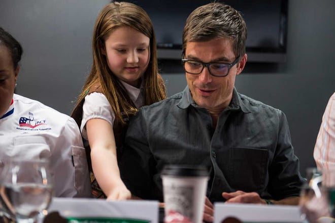 Josh Galemore/Savannah Morning News - A young Girl Scout serves one of the judges Hugh Acheson during the Tasting and Judging event.
