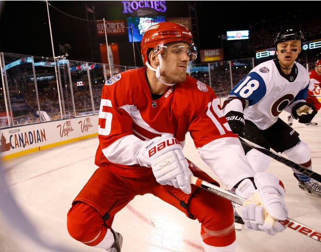 Detroit Red Wings center Riley Sheahan, front, fights for control of the puck with Colorado Avalanche center Shawn Matthias in the first period of an NHL hockey game in Coors Field Saturday, Feb. 27, 2016, in Denver. (AP Photo/David Zalubowski)