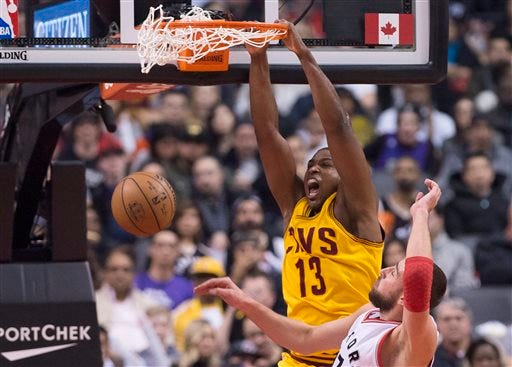 Cleveland Cavaliers center Tristan Thompson (13) dunks past Toronto Raptors center Jonas Valanciunas during the first half.