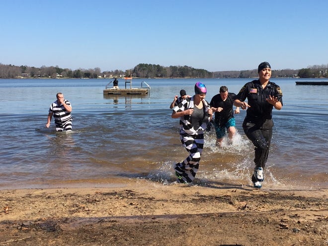 Sgt. Melanie Martin, far right, runs out of Moss Lake in Shelby with other members of the Cleveland County Sheriff’s Office during their second annual Polar Plunge to benefit the Special Olympics North Carolina on Saturday. Casey White/The Star