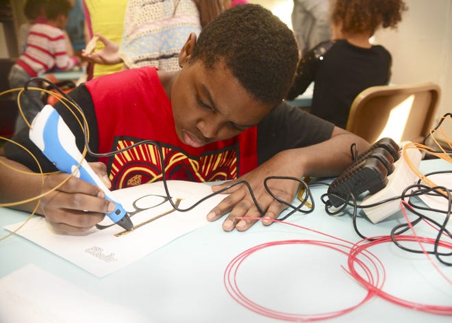 Ja'Kel Mason, 12, concentrates on making straight lines tracing a photo of a pair of glasses using a 3-D pen. Ja'Kel participates in an after-school program at the Carnegie Free Library of Beaver Falls once a week called Building Up.
