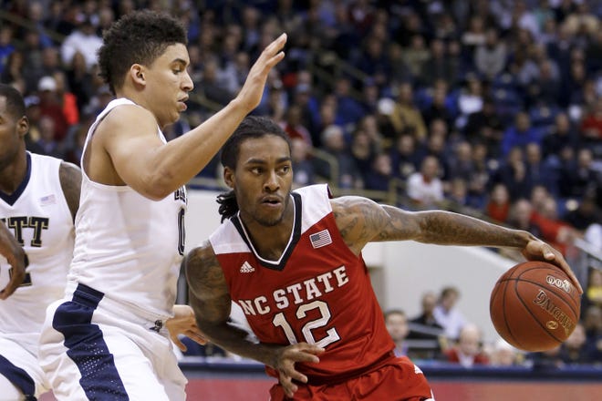 NC State's Anthony Barber (12) drives around Pitt's James Robinson in the first half of a game in January.