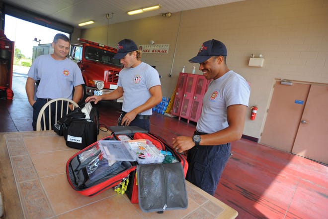 Lake County Fire Rescue's Jeff Householder, left, Daniel Wallace, center, and Albert Howard III, right, check on medical equipment from a fire truck at Lake County Fire Rescue Station 112 in the Four Corners area south of Clermont on Aug. 28, 2014.