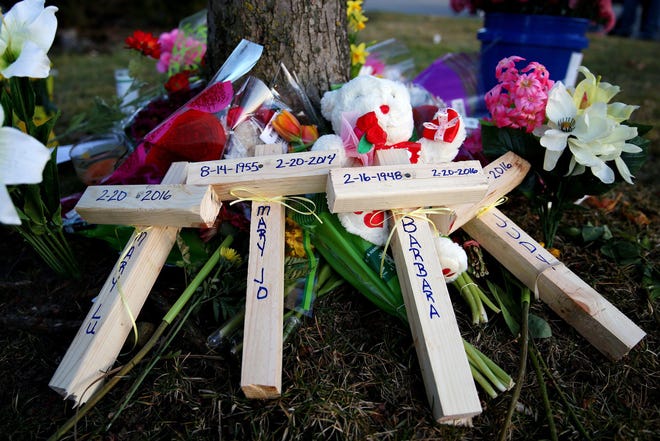 Crosses with the names of victims of a shooting spree rests by the side of a tree outside of the Cracker Barrel in Kalamazoo, Mich., Tuesday, Feb. 23, 2016. A on Tuesday vigil honored the victims of a fatal shooting spree that occurred in Kalamazoo on Saturday. (Chelsea Purgahn/Kalamazoo Gazette-MLive Media Group via AP) LOCAL TELEVISION OUT; LOCAL RADIO OUT; MANDATORY CREDIT